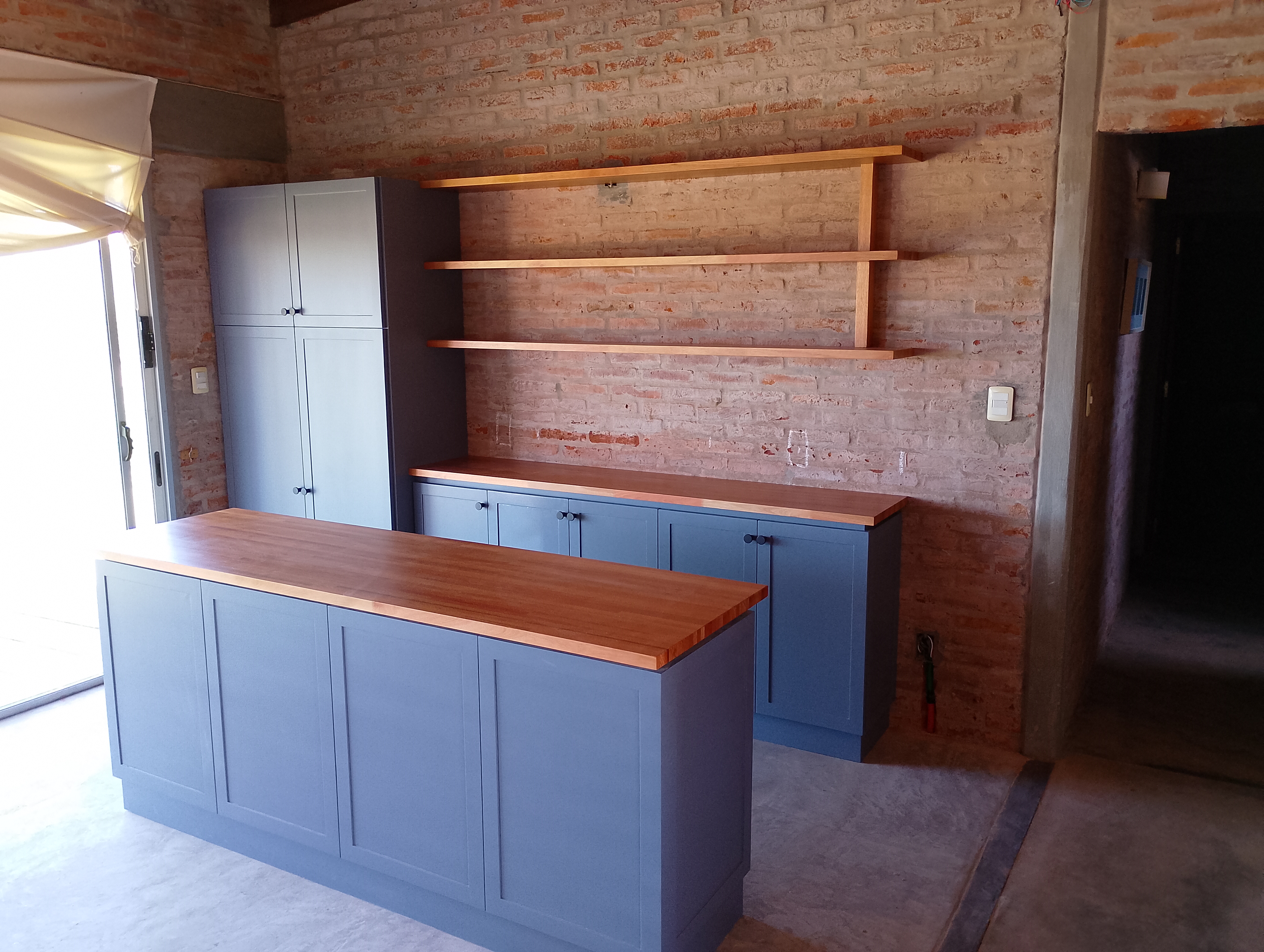 Cocina azul con isla central a medida en Montevideo